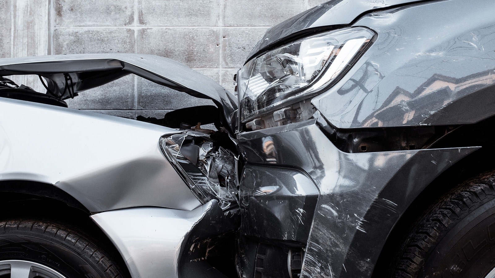 Woman calling road assistance or insurance company standing on the road after the car collision, man checking the damage
